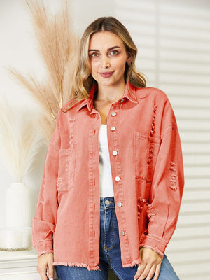 Distressed denim overshirt in orange-red with raw hem and buttoned front.