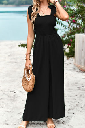 Black smocked bodice tie-strap palazzo jumpsuit with wide legs.