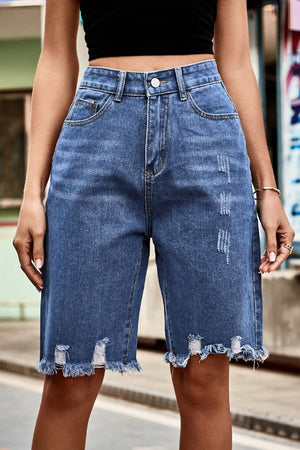 Medium wash denim bermuda shorts with frayed hem and distressed details.