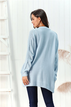 Light blue acrylic cable knit open front cardigan with braided sleeve detail.