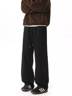 Men's black drawstring wide-leg pants with a relaxed fit.