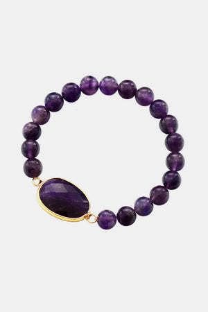 Amethyst beaded bracelet with a large faceted amethyst stone and gold bezel.