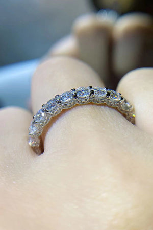 Silver eternity band ring with round moissanite stones.