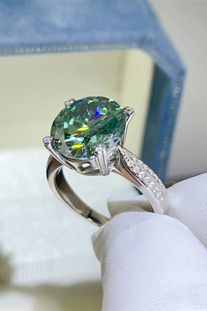 Verdant moissanite solitaire ring with diamond-accented silver band.