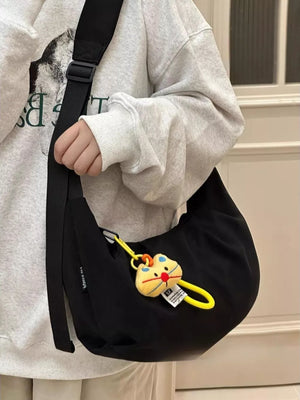 Black crescent crossbody bag with cute cat charm and yellow strap
