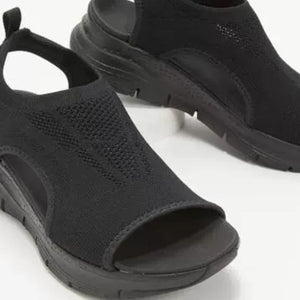Black breathable open-toe wedge sandals with a chunky sole and knit upper.