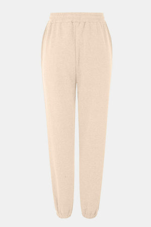 Relaxed-fit cuffed sweatpants in pastel yellow with elastic waistband and pockets.