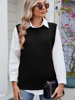 Black ribbed knit vest with crewneck, styled over a white shirt.