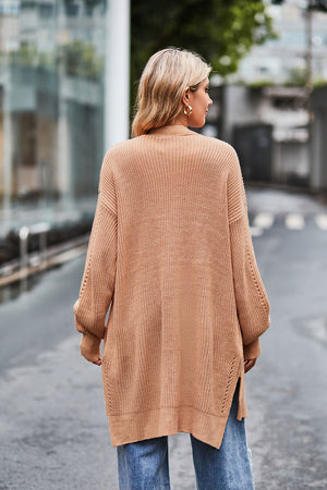 Open-knit longline cardigan in tan with side slits and textured sleeves.