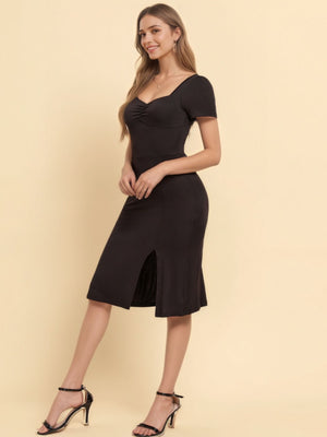 Black ruched sweetheart neck midi dress with short sleeves and a side slit.