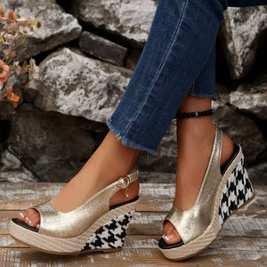 Gold open-toe wedge sandals with decorative buckle and houndstooth pattern wedge.