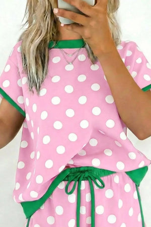 Polka dot pink pajama set with green trim and drawstring waist.