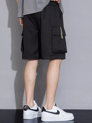 Black cargo shorts with multiple pockets and a green tab detail on the right pocket.