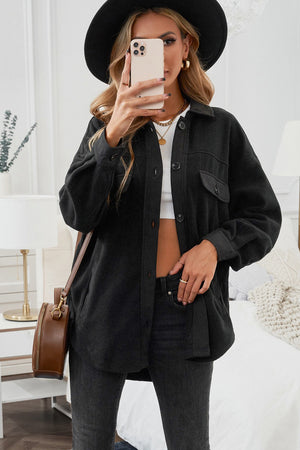 Black fleece shirt jacket with patch pockets and button front.