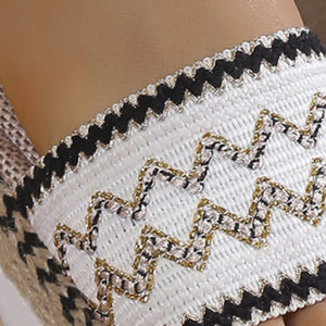 Embroidered espadrille slides with zigzag pattern and black trim.