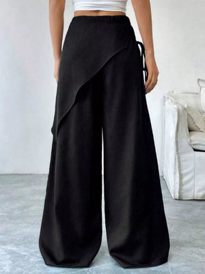 Black maternity wide-leg trousers with a high waist and wrap-style overlay.
