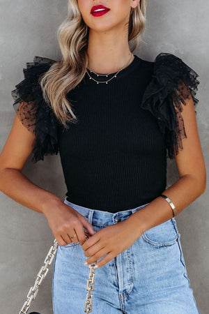 Black ribbed knit blouse with sheer polka dot ruffle sleeves