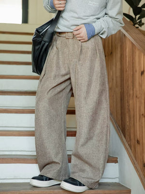 Men's wide leg trousers in beige with a belted waist and pockets.