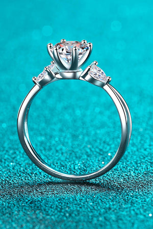 Silver moissanite ring with a large center stone and pear-shaped accent stones.
