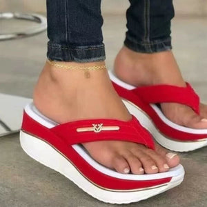 Red platform flip-flops with elegant emblem detail and white sole.