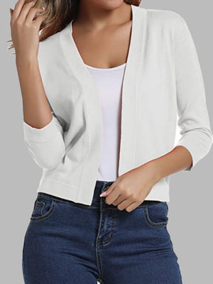 White cropped knit cardigan with elbow sleeves and open front, styled with a white tank and jeans.