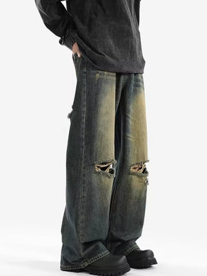 Men's vintage distressed wide-leg jeans in blue denim with ripped knees.