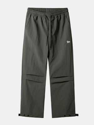 Dark gray utility joggers with drawstring waist, cargo pockets, and snap button ankles.