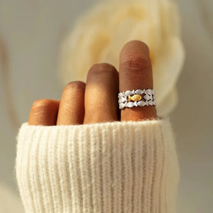 Adjustable silver ring with a row of small fish and one gold fish detail.