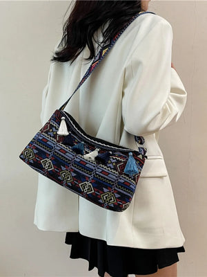 Shoulder bag with geometric embroidery and colorful tassels.
