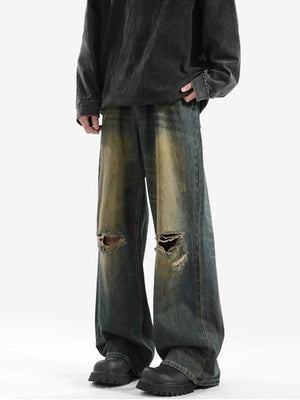 Men's vintage distressed wide-leg jeans in blue denim with ripped knees.
