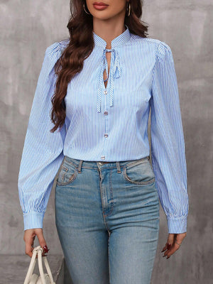 Light blue striped blouse with puffed sleeves and keyhole tie neck.