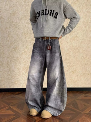 Men's vintage wash wide leg jeans in grey denim with curved seams.