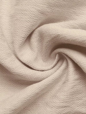 Light beige midi dress fabric detail with textured weave and tie-waist detail.