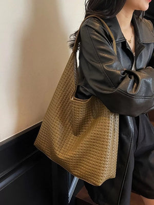 Ochre woven straw tote bag with a textured weave and leather strap.