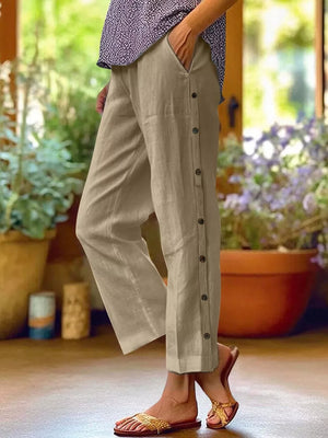 Khaki relaxed fit pants with decorative side buttons and pockets.