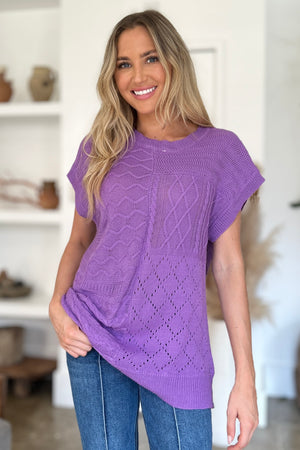 Purple knit patchwork top with short sleeves and varied stitch patterns.