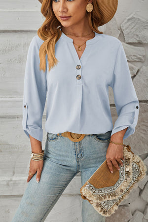 Light blue V-neck button-down blouse with cuffed sleeves and a relaxed fit.