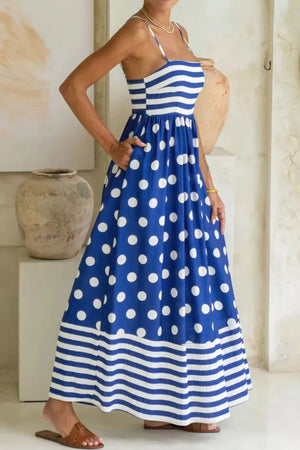 Blue polka dot maxi dress with spaghetti straps, smocked bodice, and striped hem.