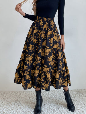Tiered midi skirt with yellow floral print on black fabric, elastic waist, and ruffled hem.