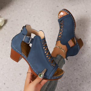 Navy blue criss-cross cut-out block heel sandals with ankle strap and buckle detail.