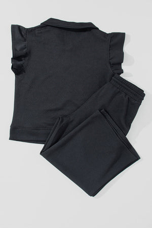 Black textured loungewear set with ruffle sleeve zip-up top and drawstring pants.