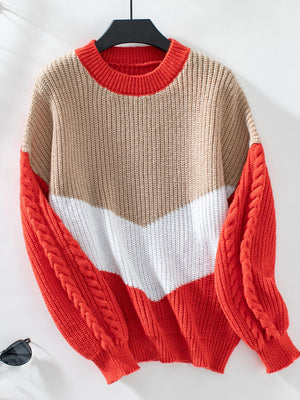 Chevron colorblock cable knit sweater in tan, white, and orange-red with cable sleeves.