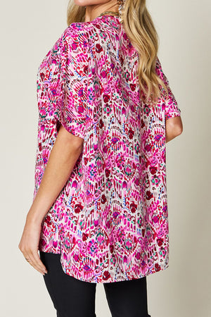 Floral ikat relaxed v-neck top in pink with short sleeves and a curved hem.