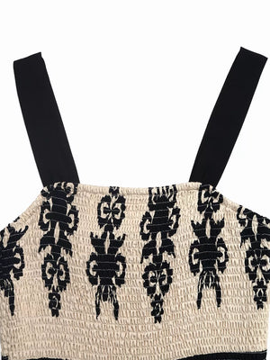 Bohemian smocked maxi dress with black straps and a black tribal pattern on cream fabric.