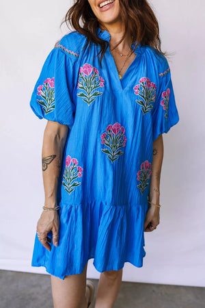 Blue embroidered floral dress with short sleeves and ruffle hem.