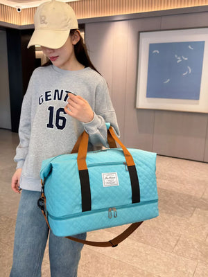 Luxurious quilted travel duffel bag in Lake Blue with brown straps and black accents.