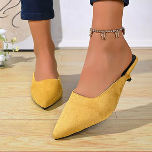 Yellow suede pointed-toe kitten heel mules with butterfly anklet.
