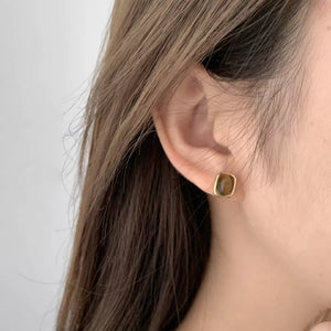 Gold color square stud earrings with polished tiger eye stone detail.
