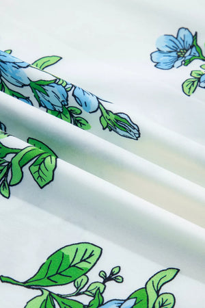 White polyester shirt with blue floral and green leaf print, showing fabric texture.