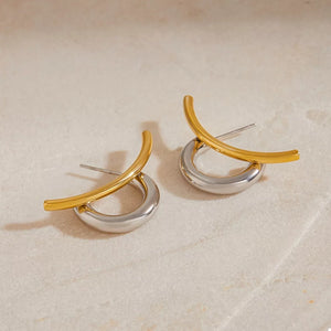 Intertwined two-tone C-hoop earrings in gold and silver with a contemporary design.
